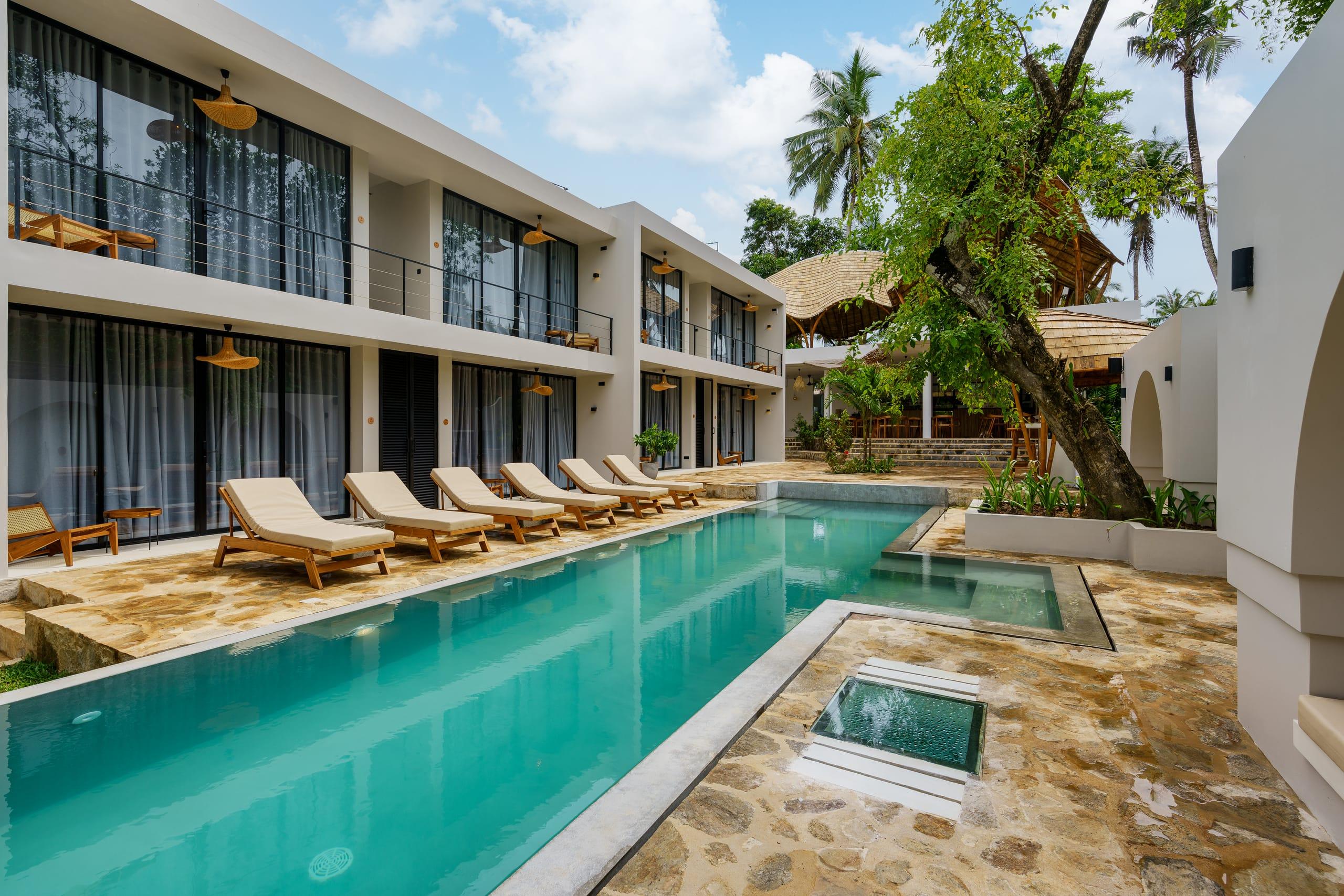 Terra Resort pool lined with loungers beneath the two-storey rooms